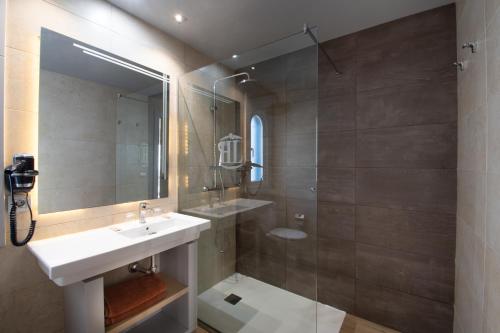 a bathroom with a sink, mirror, and bathtub at HL Paradise Island in Playa Blanca