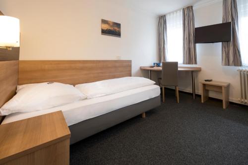 a hotel room with a bed and a desk at Hotel zur Post in Weilheim an der Teck