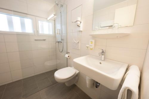 La salle de bains blanche est pourvue d'un lavabo et de toilettes. dans l'établissement Hotel zur Post, à Weilheim an der Teck