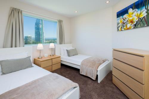 a bedroom with two beds and a window at The Waterford on Main Beach in Gold Coast