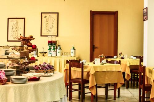 a dining room with two tables with white table cloth at Hotel Quadrifoglio in Cagliari