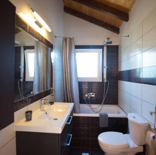 a bathroom with a sink and a toilet and a tub at Villa Zapphira Peritheia Corfu in Perítheia