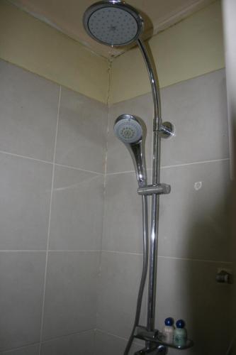 a shower with a shower head in a bathroom at Balai Serama Guesthouse in Kuala Tahan