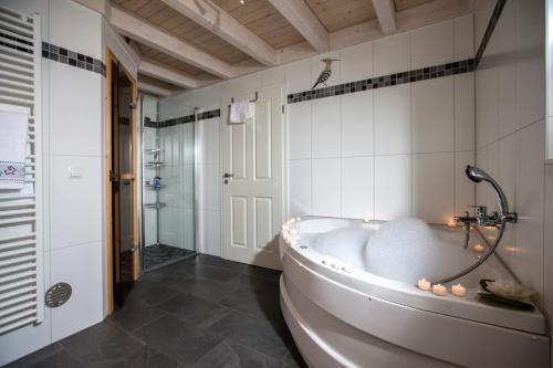 een grote badkamer met een bad en een douche bij Ferienhaus Nordhorn - Auf Wolke 7 und Seeparadies in Nordhorn