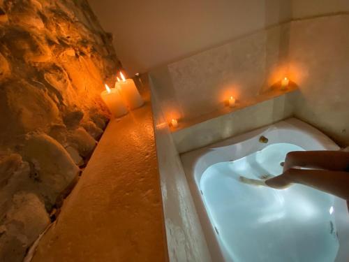 a bathroom with a bath tub with candles and lights at Villa I Barronci Resort & Spa in San Casciano in Val di Pesa