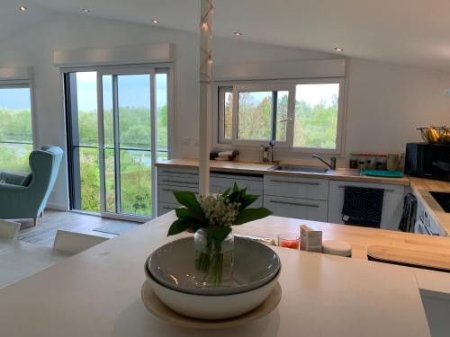 une cuisine avec un vase de fleurs sur une table dans l'établissement CHALET AU BORD DE LA SOMME, à Hem-Monacu