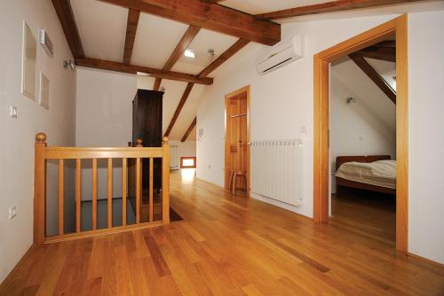 Pokój z łóżkiem i korytarzem z drewnianą podłogą w obiekcie Apartments Janks w mieście Vremski Britof