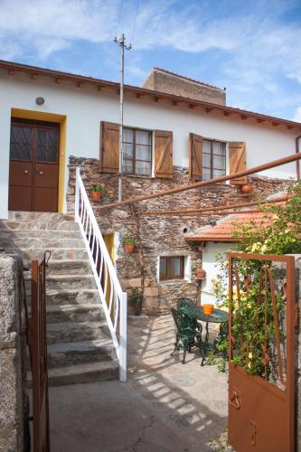 a house with stairs and a table in front of it at Casa Adalcina (casa d'avó) in Mirandela