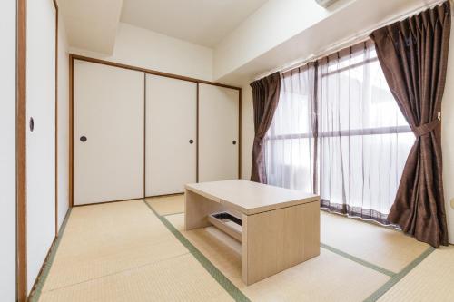 a room with a table and a large window at HOTEL MYSTAYS Otemae in Osaka