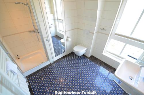 a bathroom with a shower and a toilet and a sink at Kapitänshaus Tordalk mit 3 Schlafzimmern in Norderney