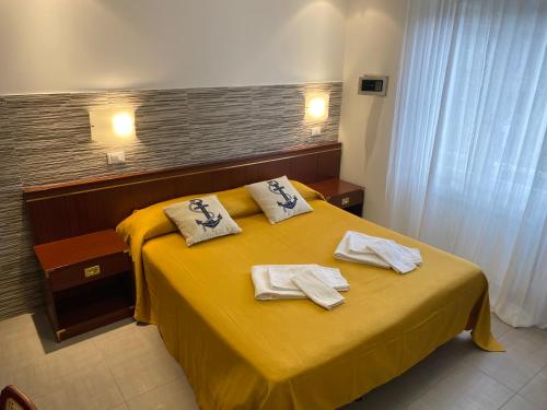 a hotel room with a yellow bed with towels on it at L'ancora di Monterosso - Cinque Terre in Monterosso al Mare