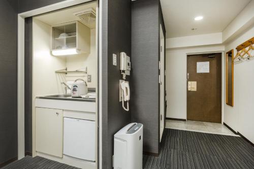 a small kitchen with a sink and a toilet at HOTEL MYSTAYS Otemae in Osaka