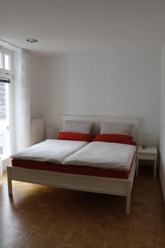 a bedroom with a large bed with red pillows at Weeze in Hau