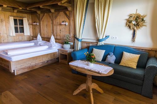 ein Schlafzimmer mit einem Bett, einem Sofa und einem Tisch in der Unterkunft Tschögglbergerhof in Jenesien