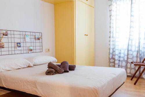 1 dormitorio con 1 cama blanca grande y toallas. en Barcelona - Art, en Barcelona