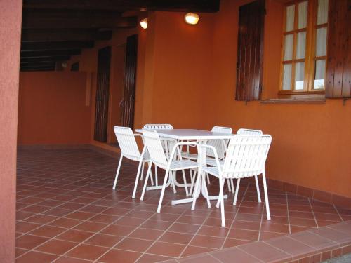 a white table and chairs on a tiled floor at Appartamenti Costa Rei in Monte Nai