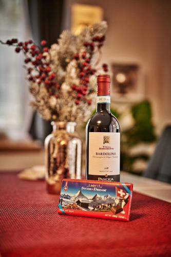 a bottle of wine sitting on a table next to a box at Apartment Breithorn - Charming home - free parking & Wifi in Lauterbrunnen