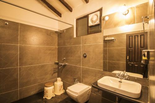 a bathroom with a sink and a toilet and a mirror at WOWSTAYZ Pachmarhi Ecotel in Pachmarhī