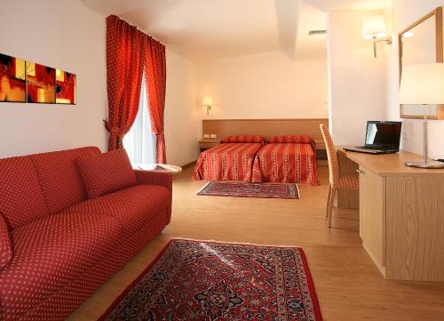 a bedroom with a red bed and a red couch at Hotel Marco Polo Airport hotel in Campalto