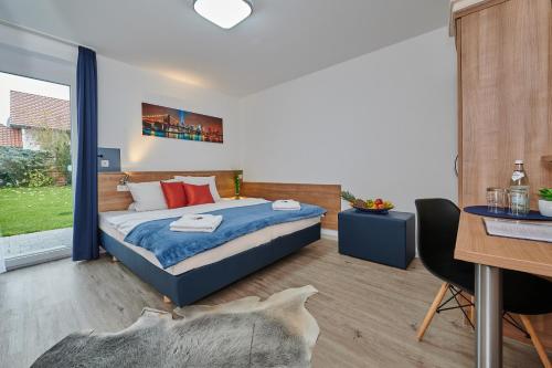 - une chambre avec un lit, une table et un bureau dans l'établissement Sunny Hotel Straubing, à Straubing