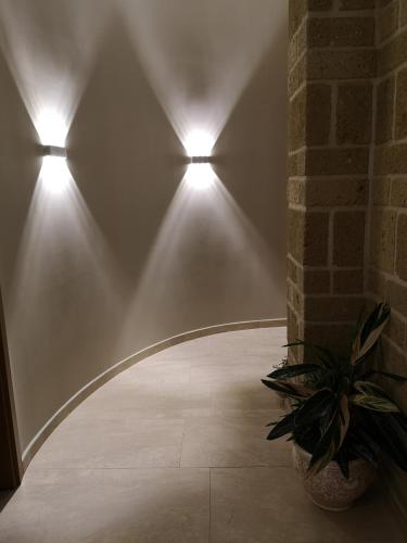 a hallway with three lights and a plant in a pot at Agriturismo La Fattoria B&B in Limatola