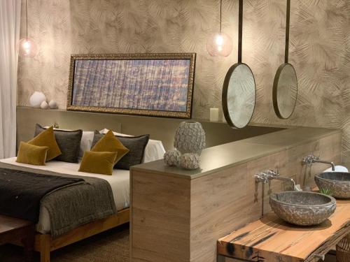 a bedroom with a bed and a sink and mirrors at Playa Grande by Tropical - Adults Only in Gavà