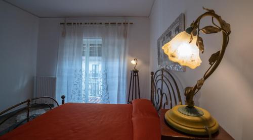 a table with a lamp on top of a table with a bed at B&B Palazzo Armini in Rogliano