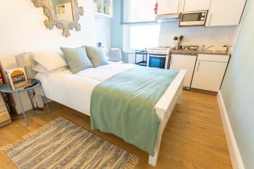 a bedroom with a large bed in a kitchen at Chic Studio Flat in West Kilburn near Queen's Park in London