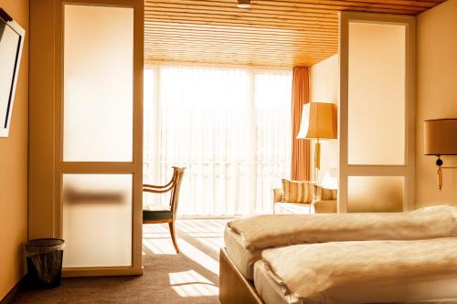 a hotel room with two beds and a window at Hillsite Smart Hotel Flims in Flims