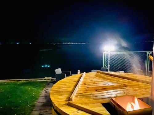 a wooden deck with a view of the water at night at Royal Mediterran in Siófok