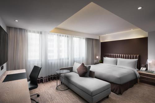 a hotel room with a bed and a chair at K Hotel Taipei Chang-An in Taipei