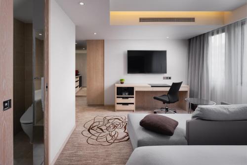 a living room with a couch and a television at K Hotel Taipei Chang-An in Taipei