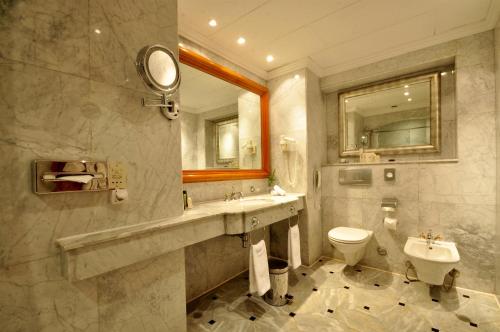 ein Badezimmer mit einem Waschbecken, einem WC und einem Spiegel in der Unterkunft Sharm Dreams Vacation Club - Aqua Park in Sharm El Sheikh