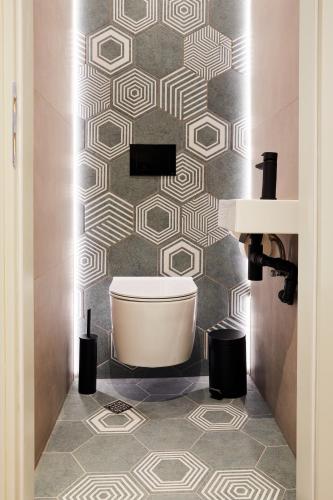 a bathroom with a toilet and a patterned wall at das Valdo in Seefeld in Tirol