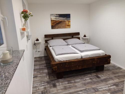 1 dormitorio con cama de madera con sábanas blancas en Lebensfreude en Goch