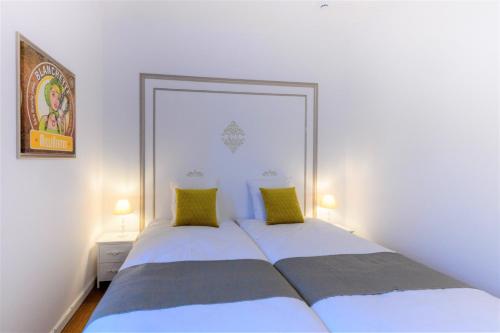 a bedroom with two beds with green pillows at Zythogite, 23 personnes, 9 chambres, 6 salles de bain, bbq, jacuzzi, jardin, billard in Tintigny