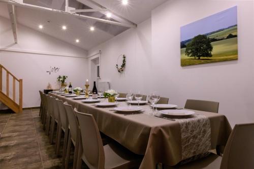 a long dining room with a long table and chairs at Zythogite, 23 personnes, 9 chambres, 6 salles de bain, bbq, jacuzzi, jardin, billard in Tintigny