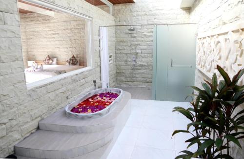 ein Badezimmer mit einer Badewanne und einem Spiegel in der Unterkunft Villa Latour in Seminyak