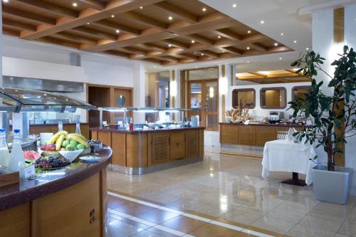 a large kitchen with a island with fruits on it at Thalassa Beach Resort & Spa (Adults Only) in Agia Marina Nea Kydonias