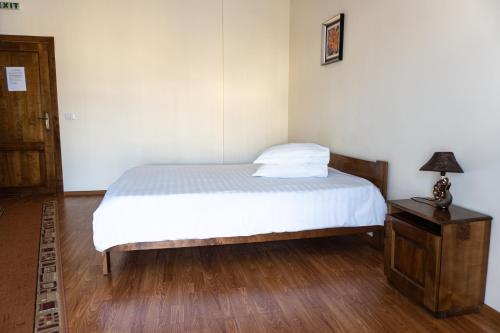 a bedroom with a bed and a table with a lamp at Pensiunea Splendid in Dorohoi