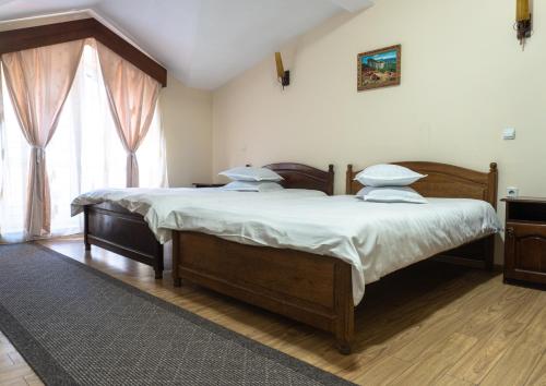 a bedroom with a large bed with white sheets and pillows at Pensiunea Splendid in Dorohoi