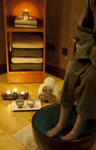 a person with their feet in a bowl on the floor at Canal Court in Newry