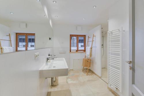 a white bathroom with a sink and a mirror at Ferienwohnung Mittertenn Alte Gendarmerie Übersee in Übersee