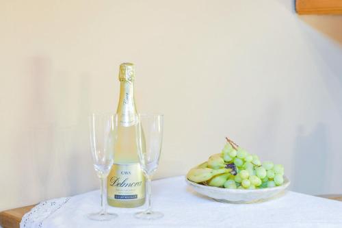 a bottle of champagne sitting next to a bowl of grapes at Beim Kreuzfelder Zwiesel in Inzell