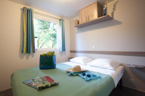 Un pat sau paturi într-o cameră la Camping Le Paradis