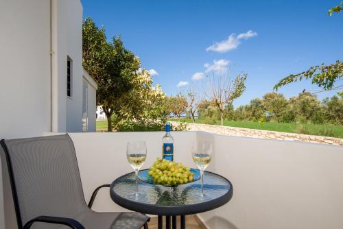 a table with two glasses of wine and a bowl of fruit at Oasea in Tavronitis