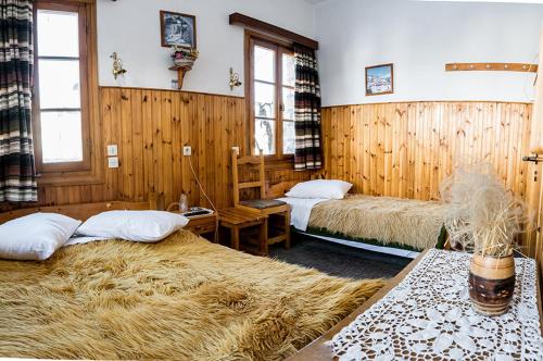 two beds in a room with wooden walls at Filoxeni Gonia in Metsovo