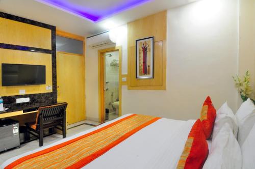 a bedroom with a bed and a desk and a television at Hotel Karlo Kastle - Paharganj - New Delhi in New Delhi