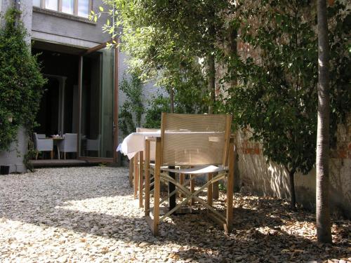 a table with a chair and umbrella in front of a tree at Design B&B Logidenri in Ghent