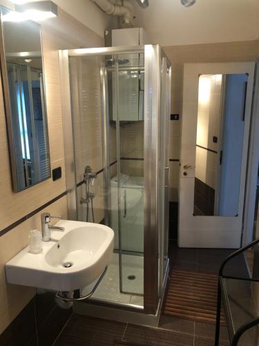 een badkamer met een wastafel en een glazen douche bij gardasee sirmione in Sirmione